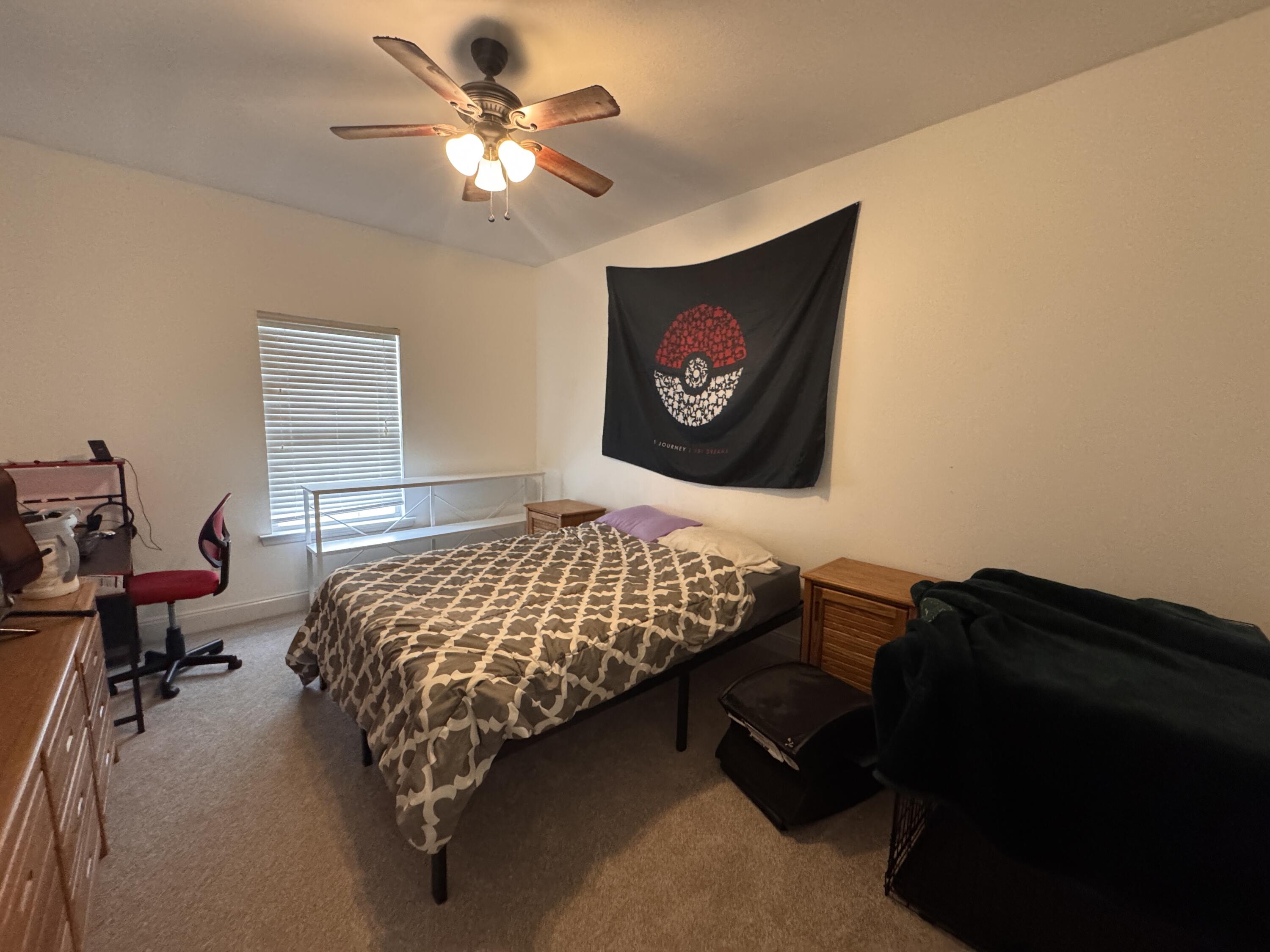 4413 Mirada Way Crestview, FL 32539 - Photo 20 of 27 a bed sitting in a bedroom next to a window with a chandelier and dresser