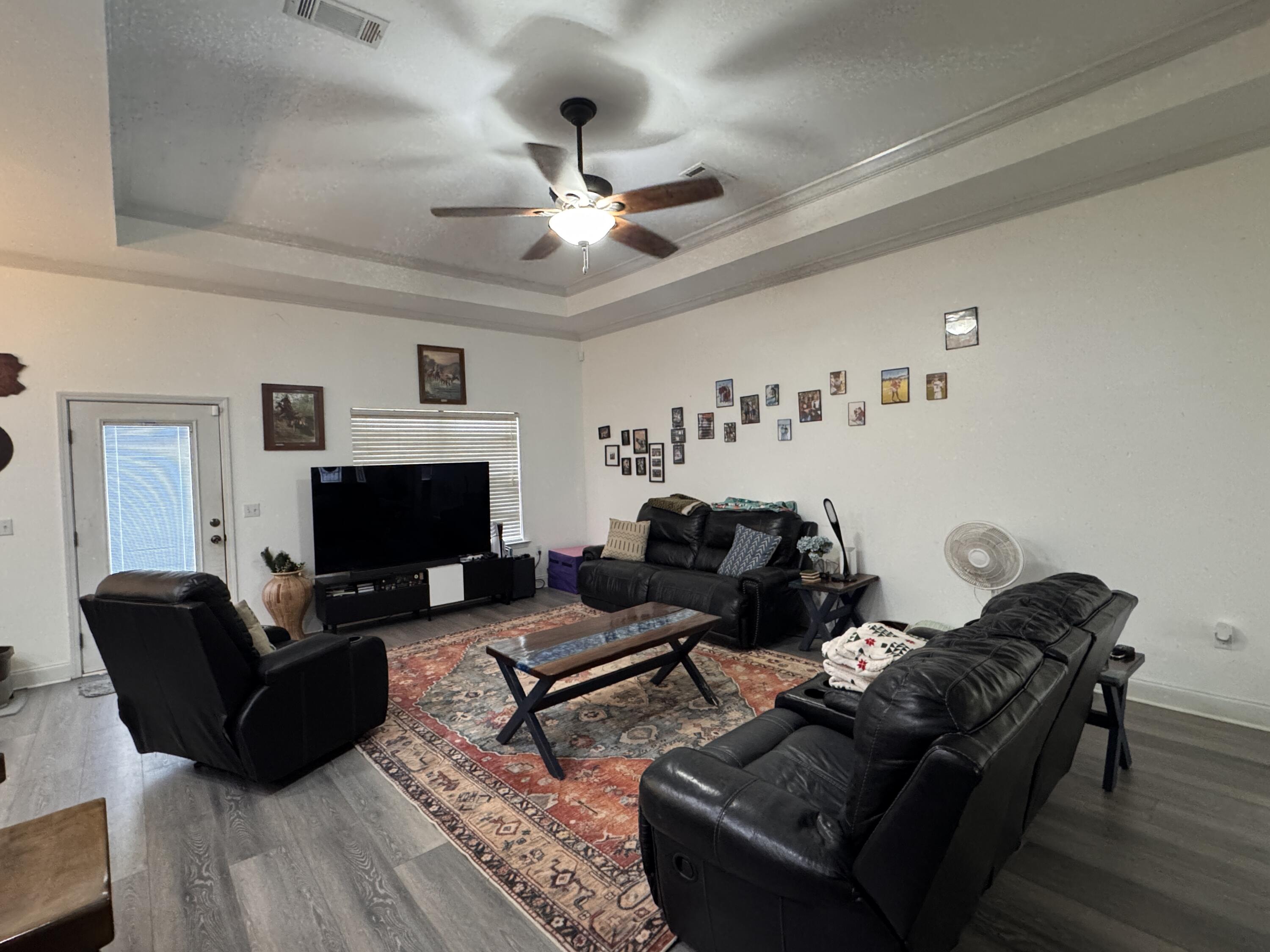 4413 Mirada Way Crestview, FL 32539 - Photo 4 of 27 a living room with furniture a flat screen tv and a fireplace