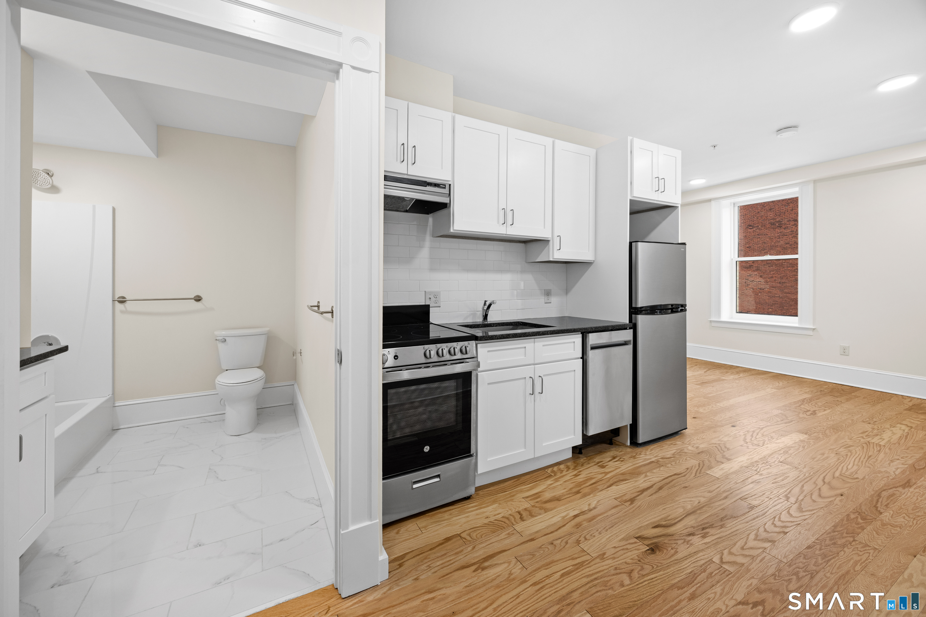 1355 Main Street, Unit 405 Hartford, CT 06103 - Photo 3 of 11 a kitchen with a sink a stove and cabinets