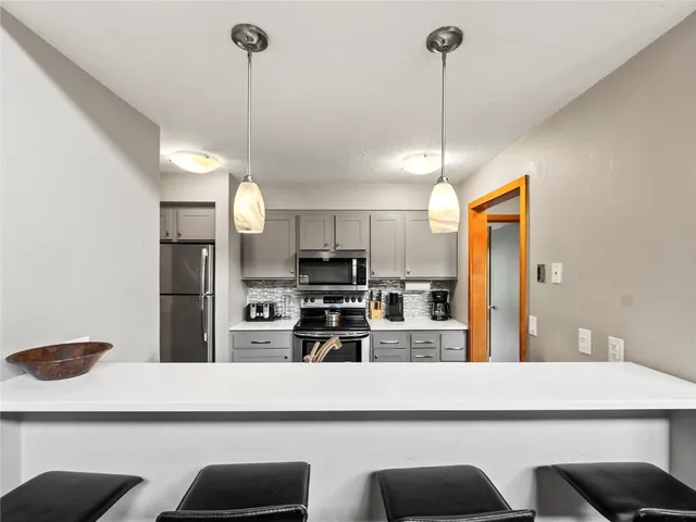 a kitchen with kitchen island white cabinets and stainless steel appliances