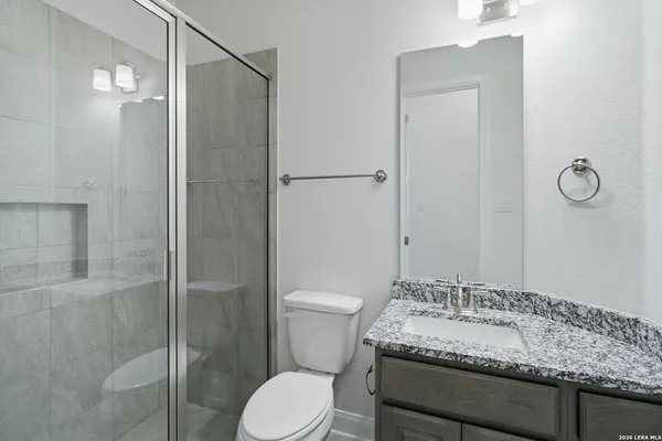 a bathroom with a granite countertop sink toilet and shower
