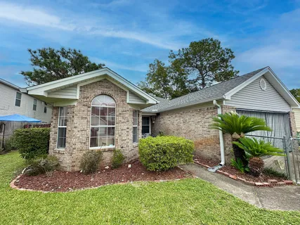 a front view of a house with a yard and potted plants