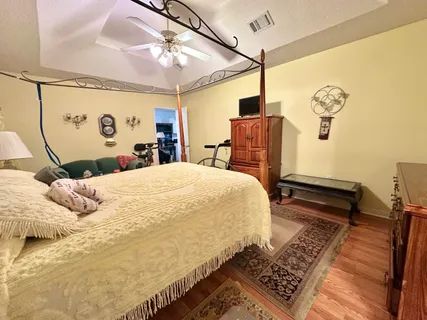 a bedroom with bed and wooden floor