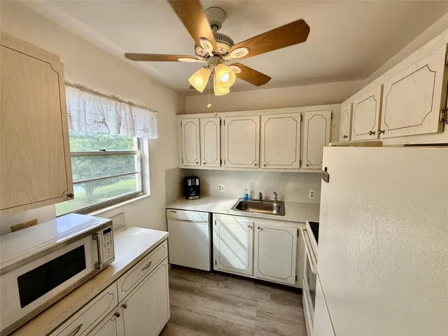 a room with wooden floor pool table and chairs