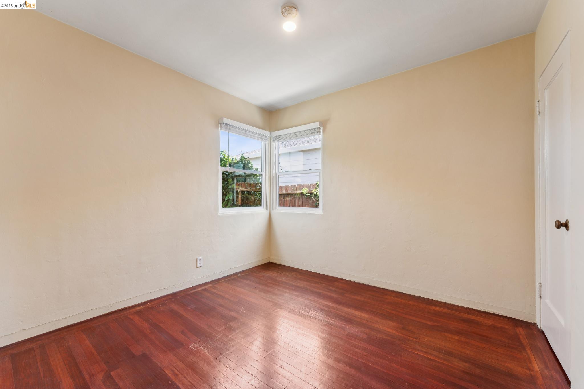 2879 Rheem Avenue Richmond, CA 94804 - Photo 32 of 45 Room featuring wood-finish flooring, light-toned walls, and a corner window installation with white window treatments