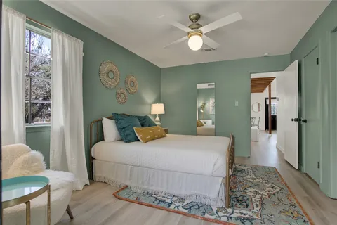 a bedroom with a large bed and a chandelier