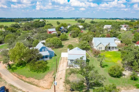 an aerial view of a house with a garden and lake view