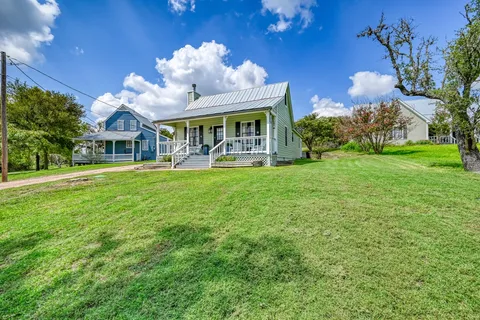 a view of a house with a big yard and potted plants