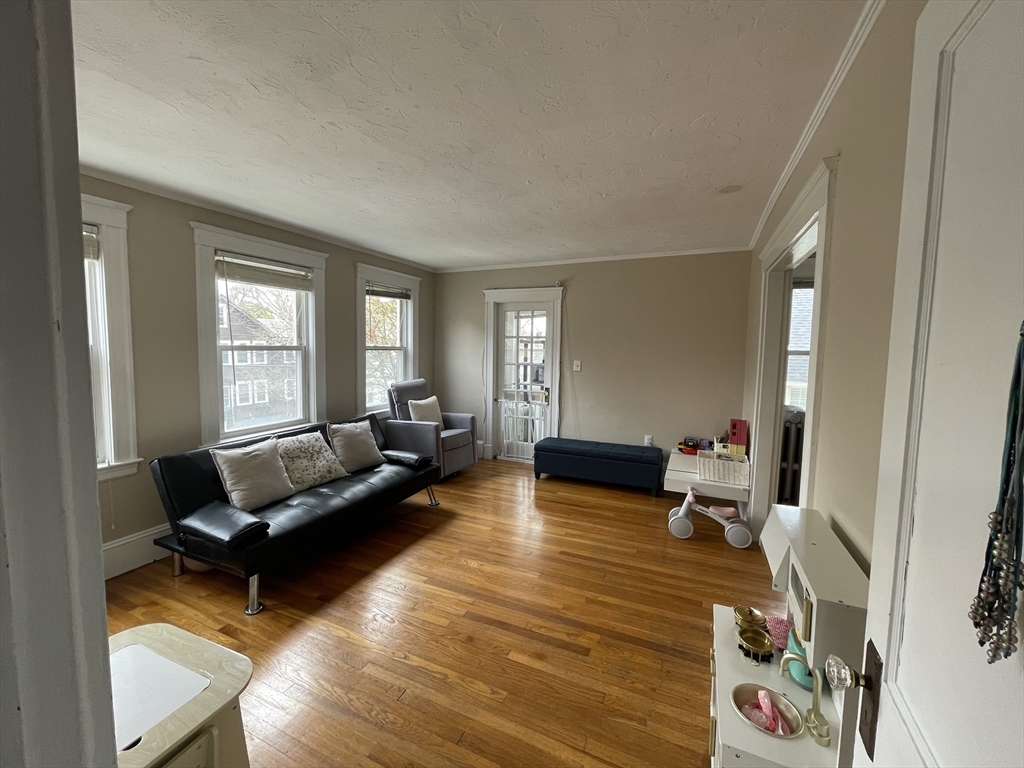 29-31 Bradford Road, Unit 31 Watertown, MA 02472 - Photo 3 of 11 a living room with furniture window and wooden floor