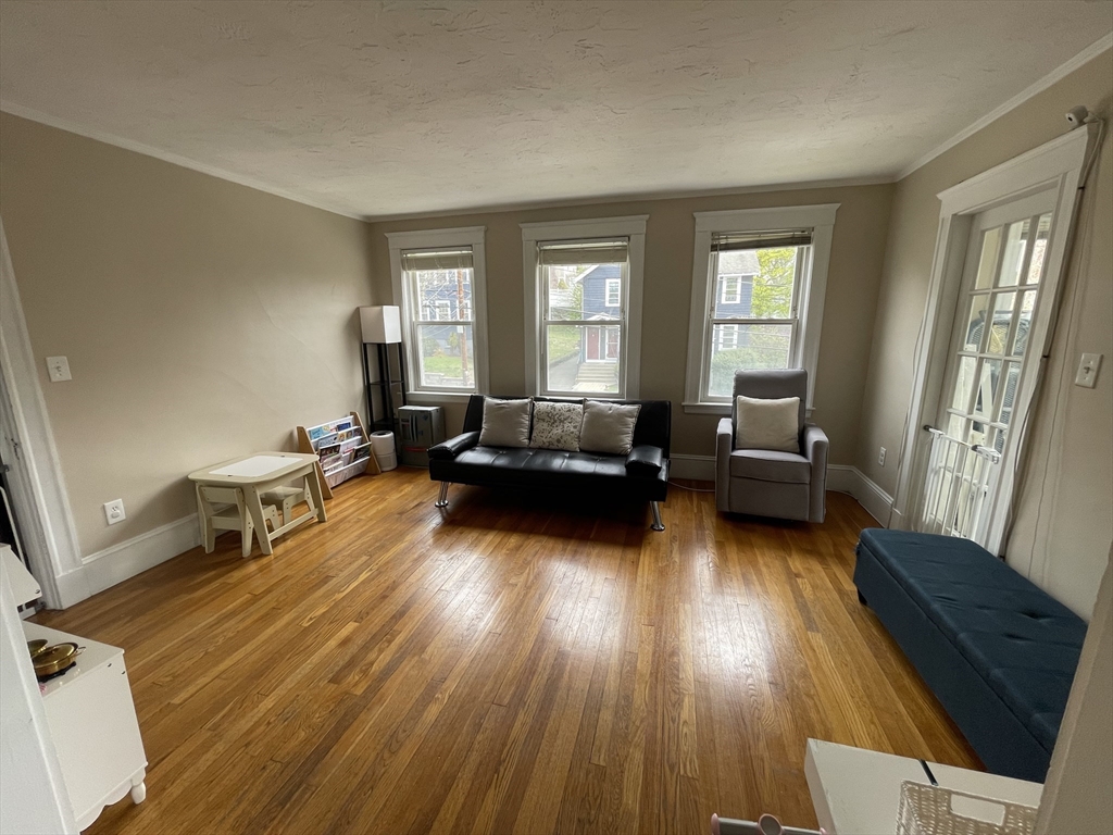 29-31 Bradford Road, Unit 31 Watertown, MA 02472 - Photo 4 of 11 a living room with furniture and a wooden floor