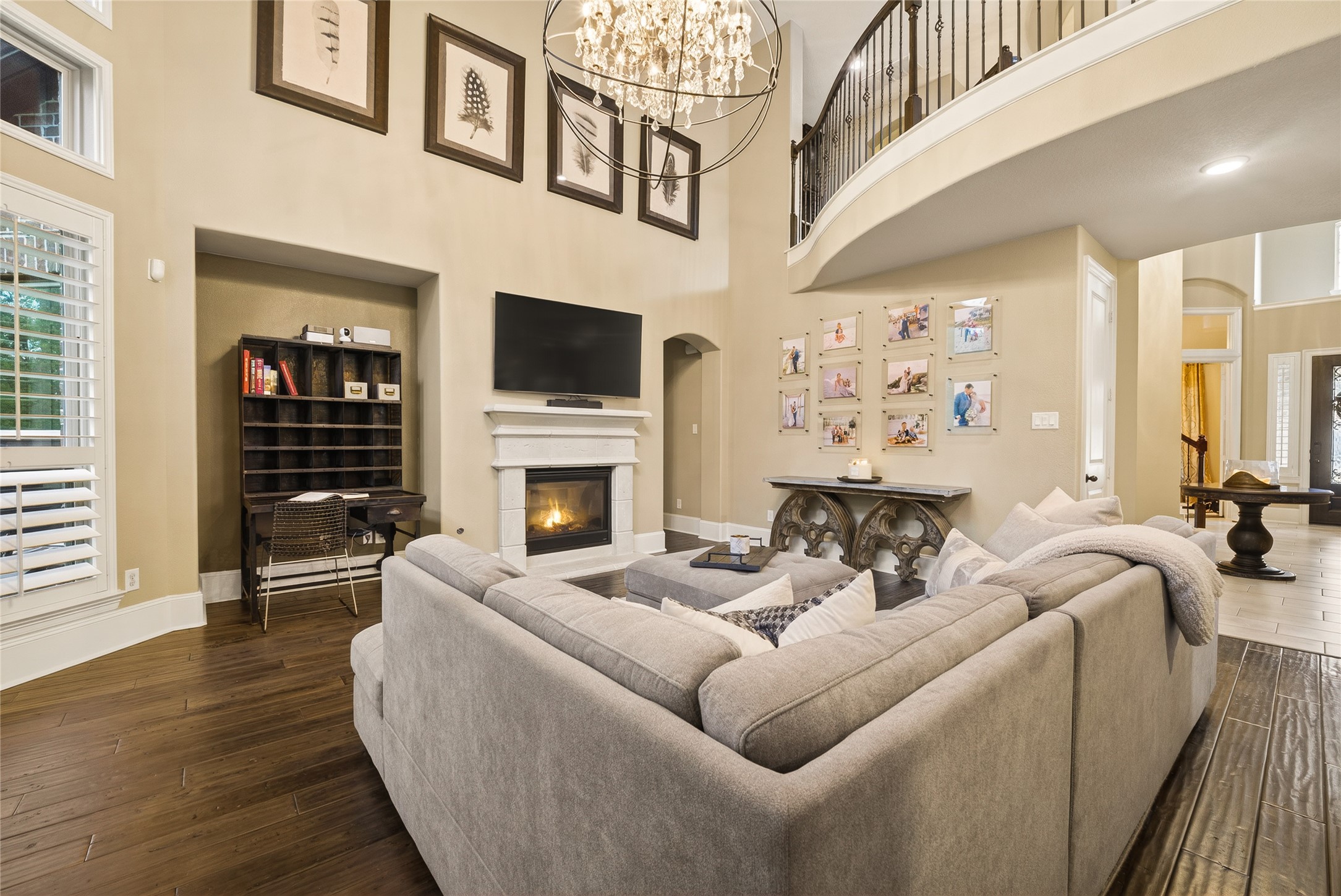 7907 Augusta Creek Court Spring, TX 77389 - Photo 19 of 49 Enjoy family time snuggled up in front of this fireplace. Elegant hardwood floors, natural from all the large windows with shutters, and a grand chandelier adds a touch of luxury.