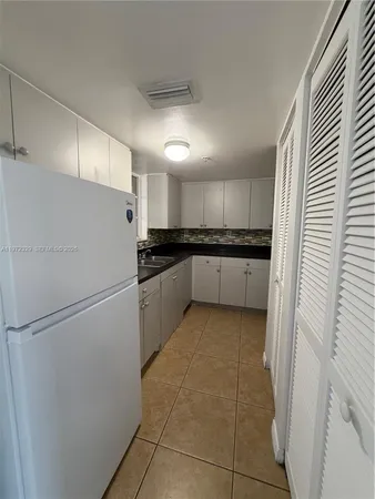 a kitchen with granite countertop a refrigerator and a sink