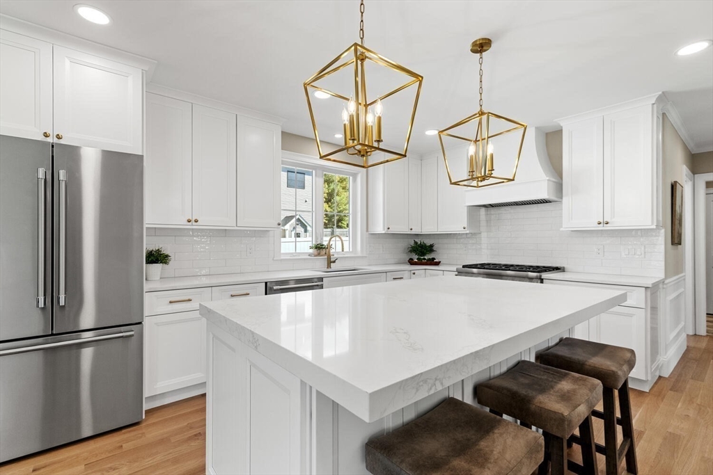 199 Nahant Street Wakefield, MA 01880 - Photo 2 of 39 a kitchen with a table a sink cabinets and stainless steel appliances