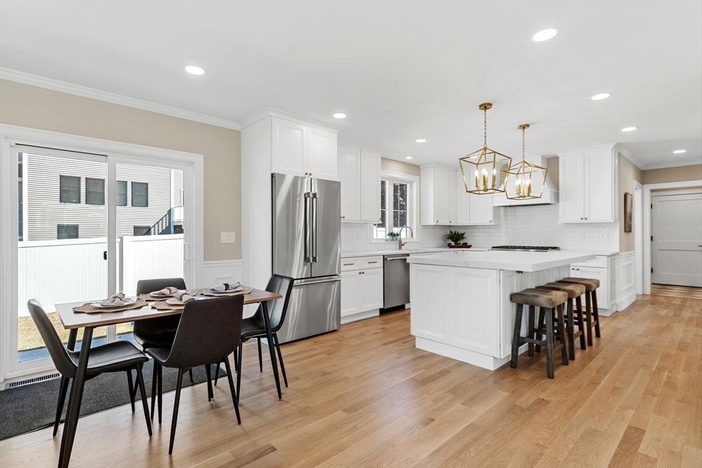 199 Nahant Street Wakefield, MA 01880 - Photo 4 of 39 a kitchen with stainless steel appliances a dining table chairs refrigerator and sink