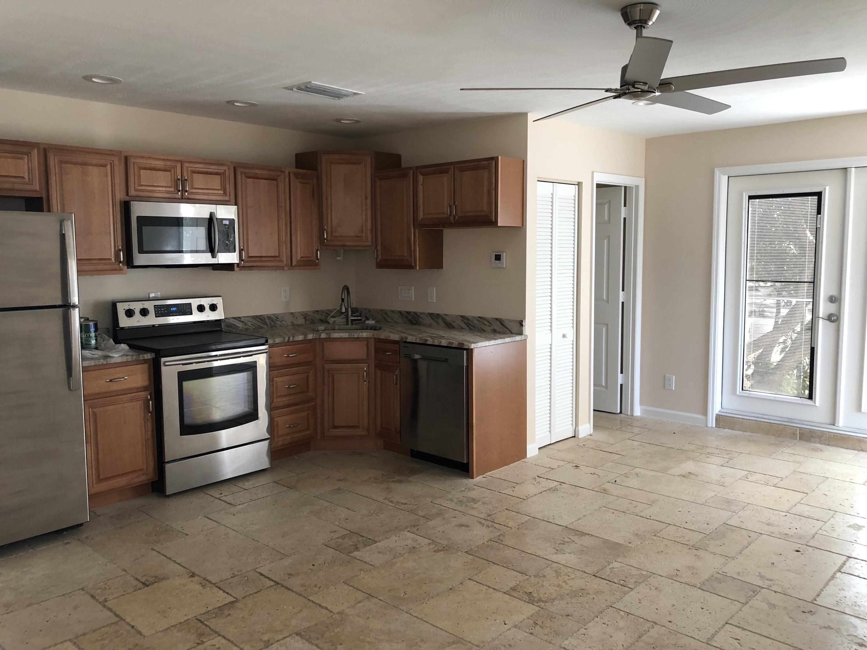 477 Southeast Riverside Drive Stuart, FL 34994 - Photo 2 of 7 a kitchen with stainless steel appliances granite countertop a stove top oven a sink and a refrigerator