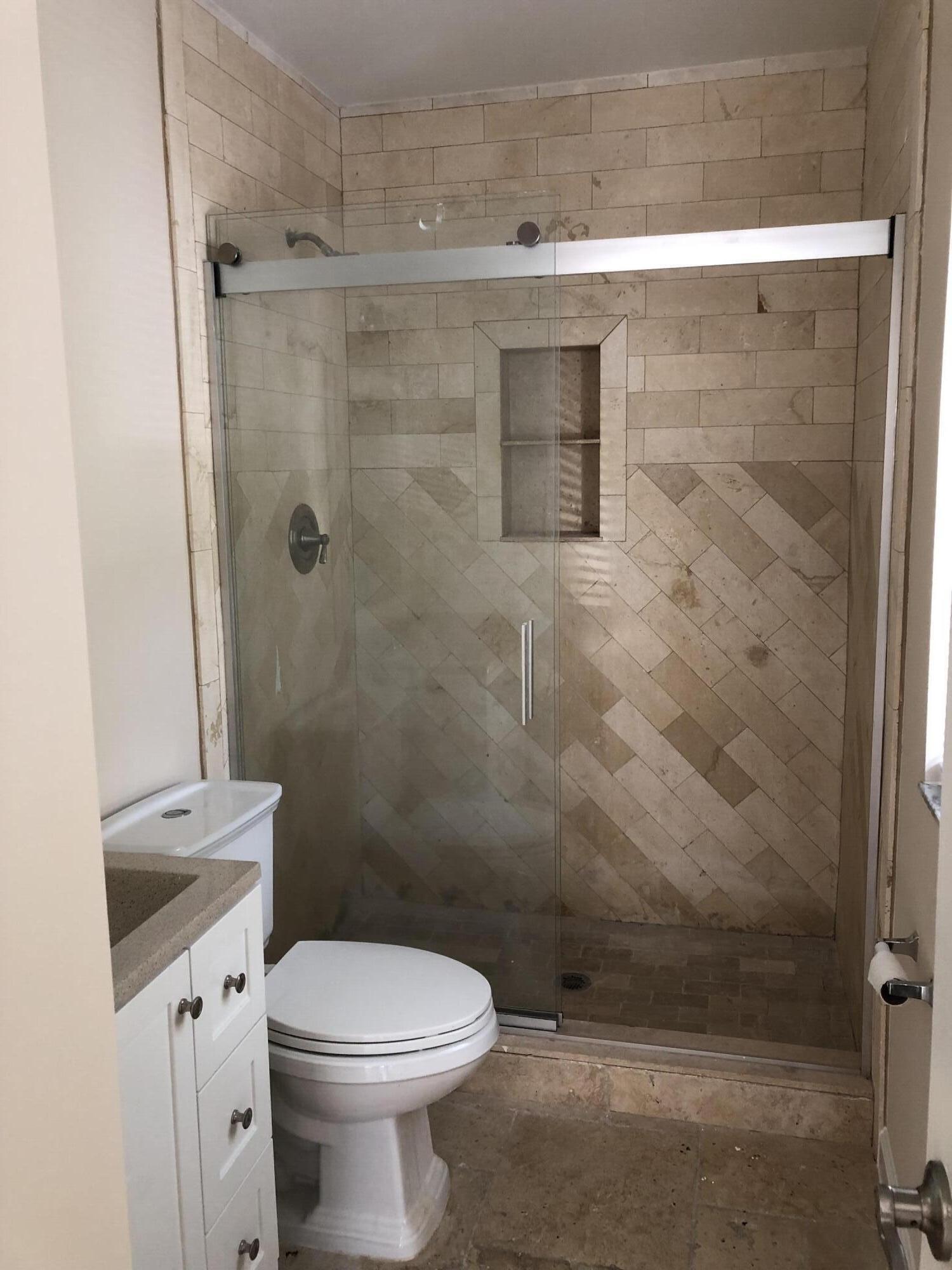 477 Southeast Riverside Drive Stuart, FL 34994 - Photo 4 of 7 a bathroom with a toilet a sink and shower