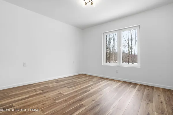 a view of a hallway with closet and wooden floor