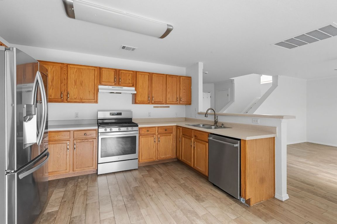 617 Riverway Lane Leander, TX 78641 - Photo 11 of 33 a kitchen with stainless steel appliances granite countertop a sink stove and refrigerator