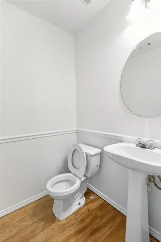 a bathroom with a toilet a sink and mirror