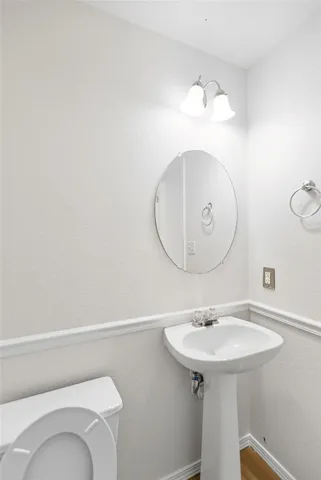a bathroom with a sink mirror and toilet