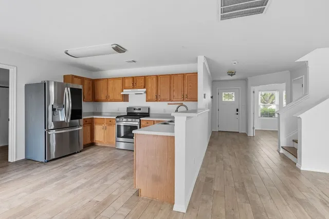 a kitchen with furniture a refrigerator and a stove top oven