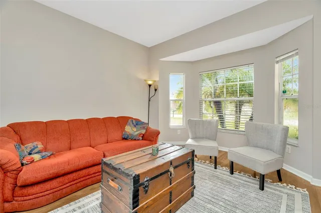 a living room with furniture and a potted plant with wooden floor