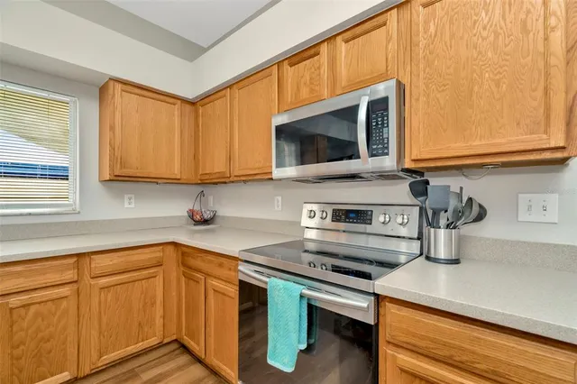 a kitchen with stainless steel appliances a stove microwave and sink