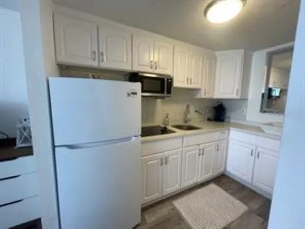 a kitchen with cabinets and a refrigerator
