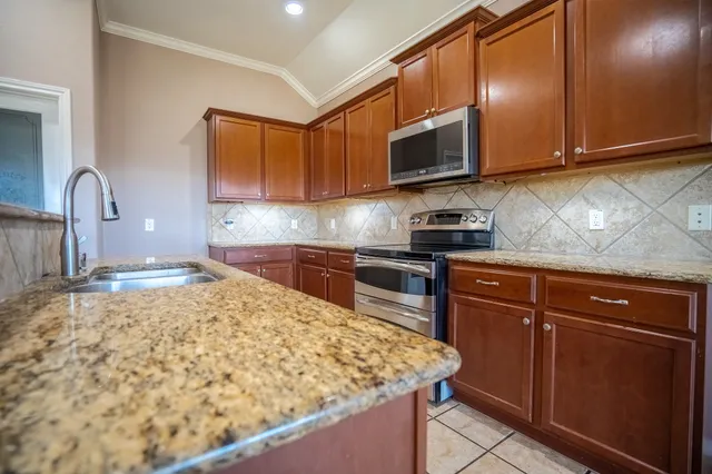 a kitchen with stainless steel appliances granite countertop a sink stove and microwave