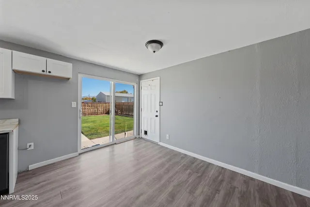 a view of empty room with wooden floor and window
