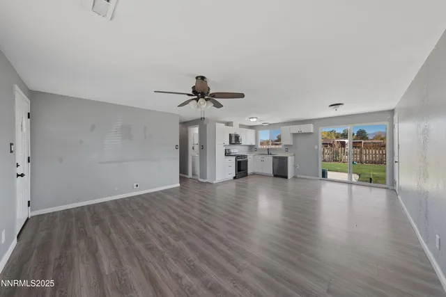 a view of empty room with wooden floor and window