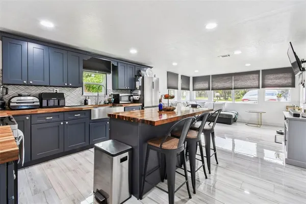 a kitchen with a table chairs sink microwave and cabinets