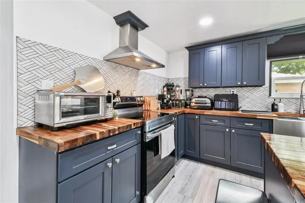 a kitchen with stainless steel appliances granite countertop a stove a sink and a microwave