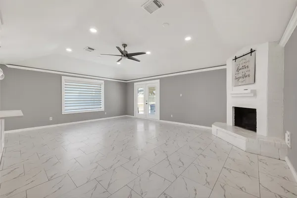 a view of an empty room with a fireplace and a window