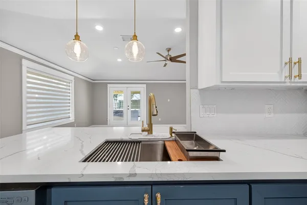 a view of kitchen with a sink and chandelier