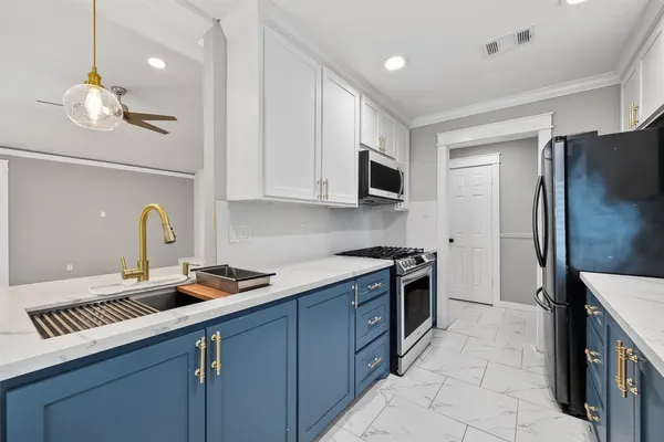 a kitchen with stainless steel appliances granite countertop a sink stove and refrigerator