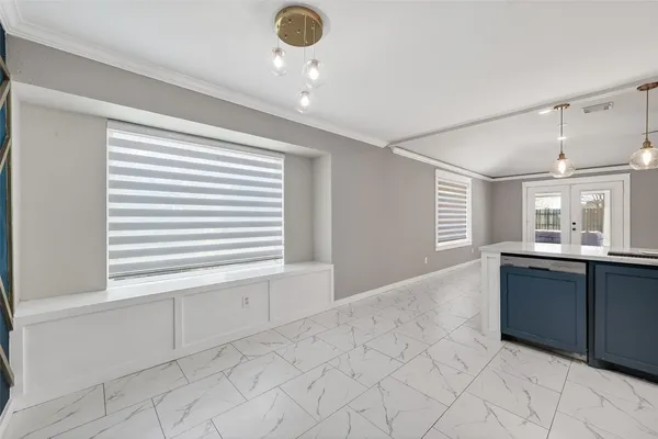 a view of an empty room with window and cabinet