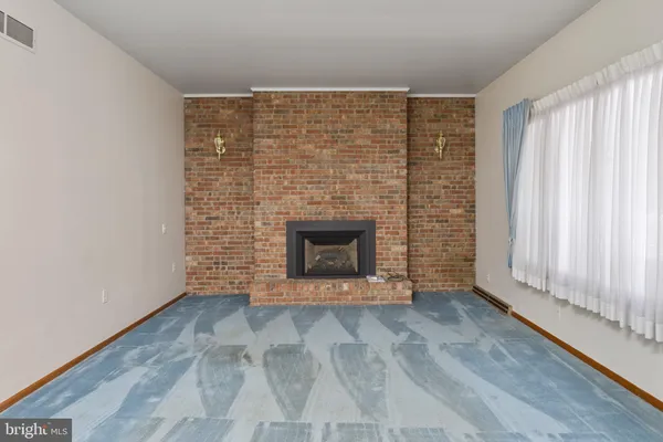 a view of an empty room with a fireplace and a window