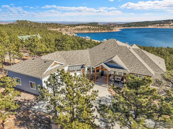 an aerial view of a house with a garden and lake view