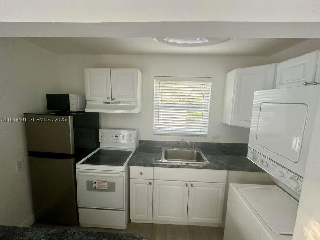 1150 Southwest 22nd Street, Unit 1 Miami, FL 33129 - Photo 3 of 13 a kitchen with granite countertop white cabinets and refrigerator
