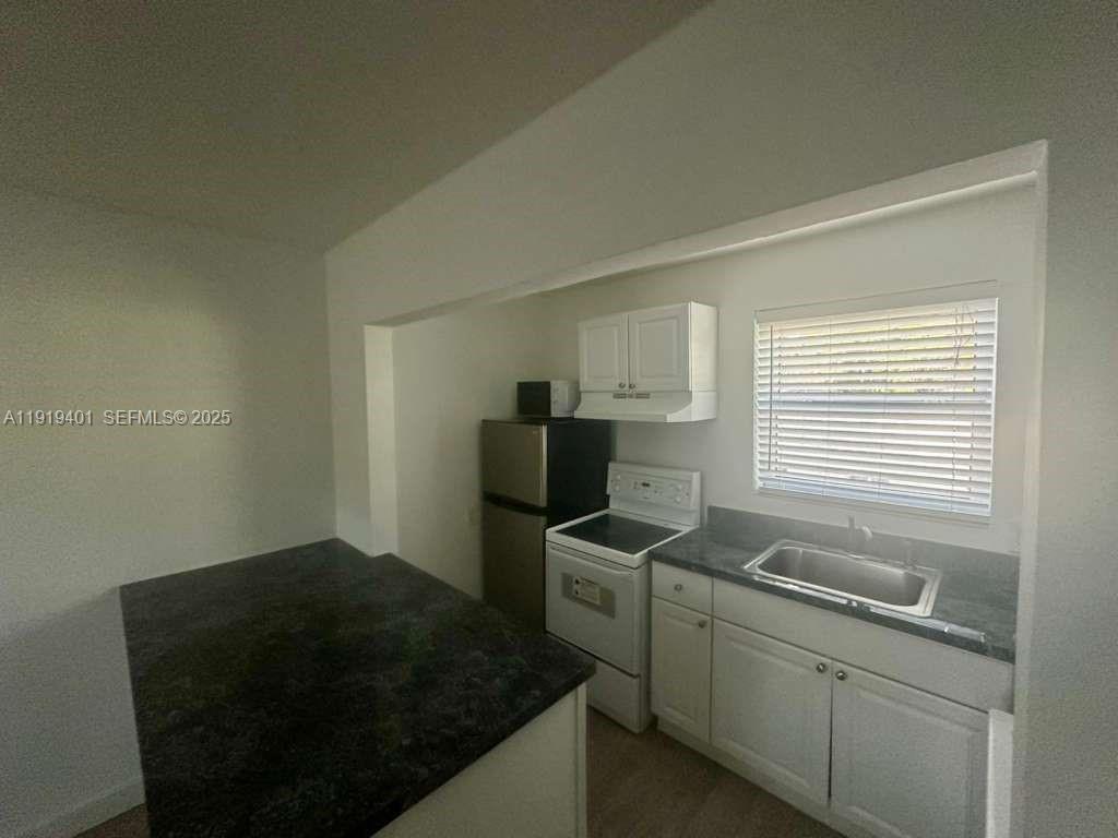 1150 Southwest 22nd Street, Unit 1 Miami, FL 33129 - Photo 5 of 13 a kitchen with a sink cabinets and a window