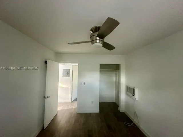 a view of a hallway with wooden floor and a cabinet