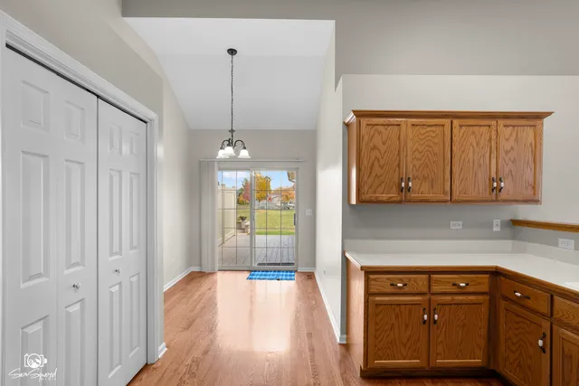 a kitchen with stainless steel appliances granite countertop a refrigerator a sink dishwasher a stove and white countertops with wooden floor