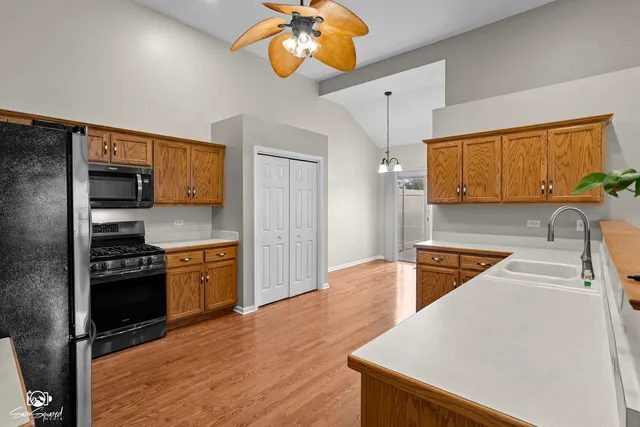 a kitchen with stainless steel appliances granite countertop a sink a stove and a refrigerator