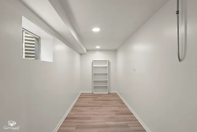 a view of a hallway with wooden floor and closet