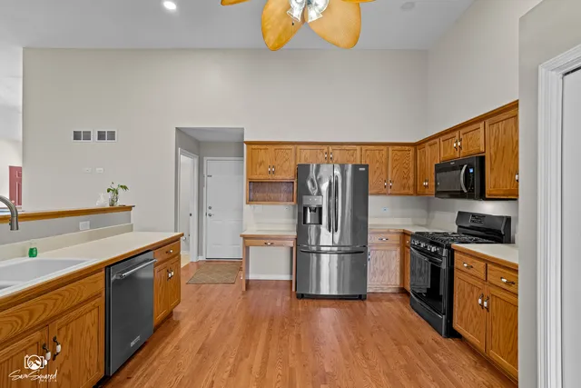 a kitchen with stainless steel appliances a refrigerator and a stove top oven