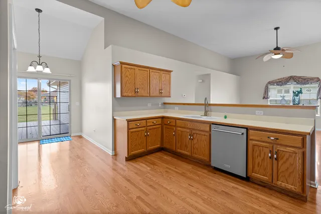 a kitchen with stainless steel appliances granite countertop a sink a stove a counter space and cabinets