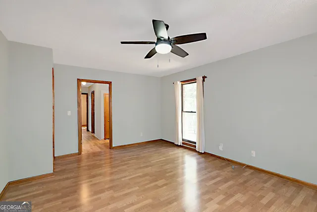 an empty room and hallway with wooden floor