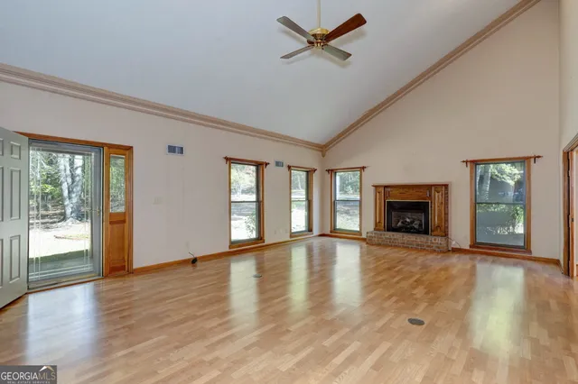 a view of an empty room with window and fire place