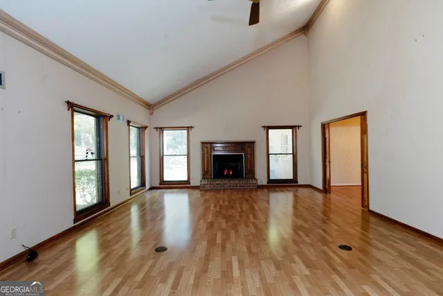 wooden floor fireplace and windows in an empty room
